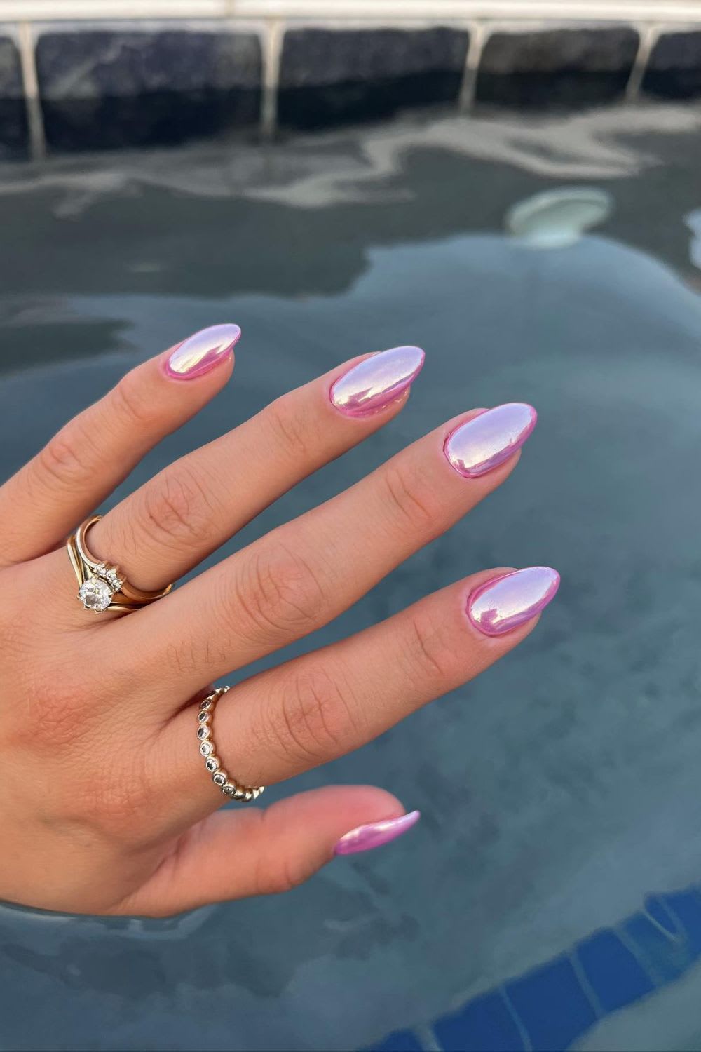 Almond-shaped chrome nails with iridescent pink-purple finish, showcasing a trendy summer 2025 nail style