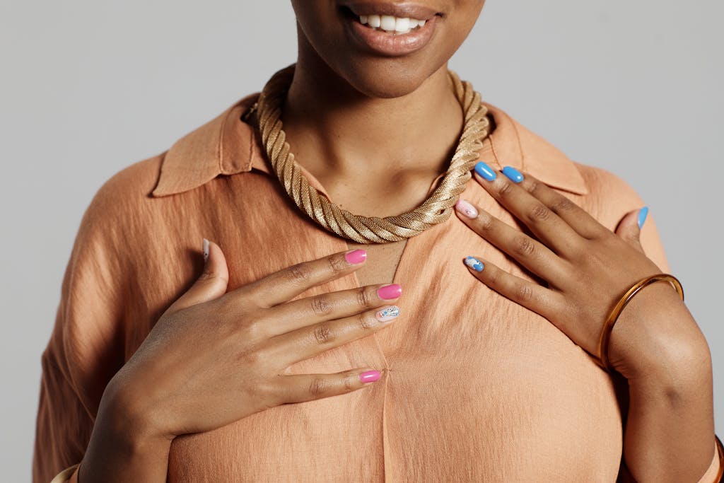 Elegant portrait of a woman showcasing fashion jewelry and colorful nails.
