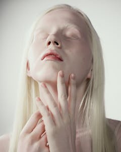 Close-up portrait capturing a peaceful expression of a woman with albinism.