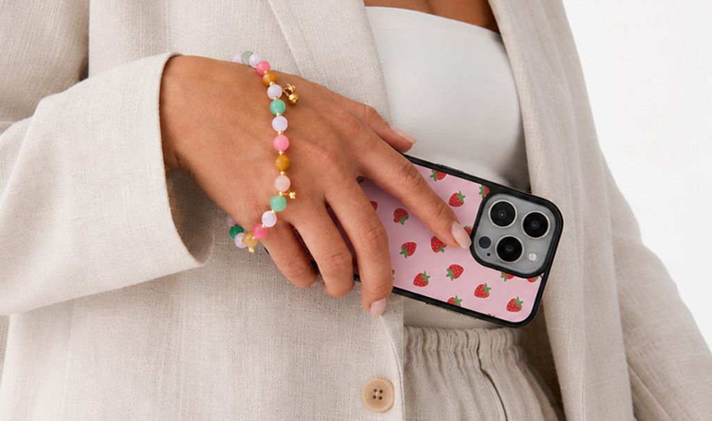Różowe etui z nadrukiem truskawek i nude manicure