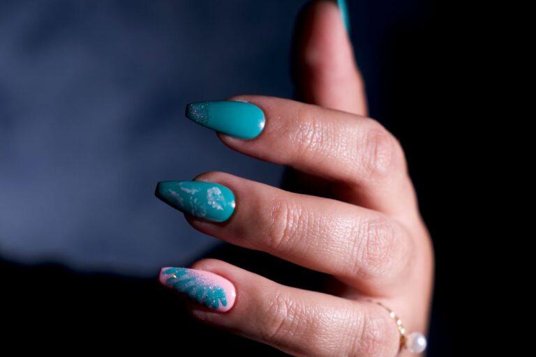Turkusowy manicure na paznokciach w kształcie trumienki ze srebrnymi metalicznymi akcentami i różowym paznokciem z liściem